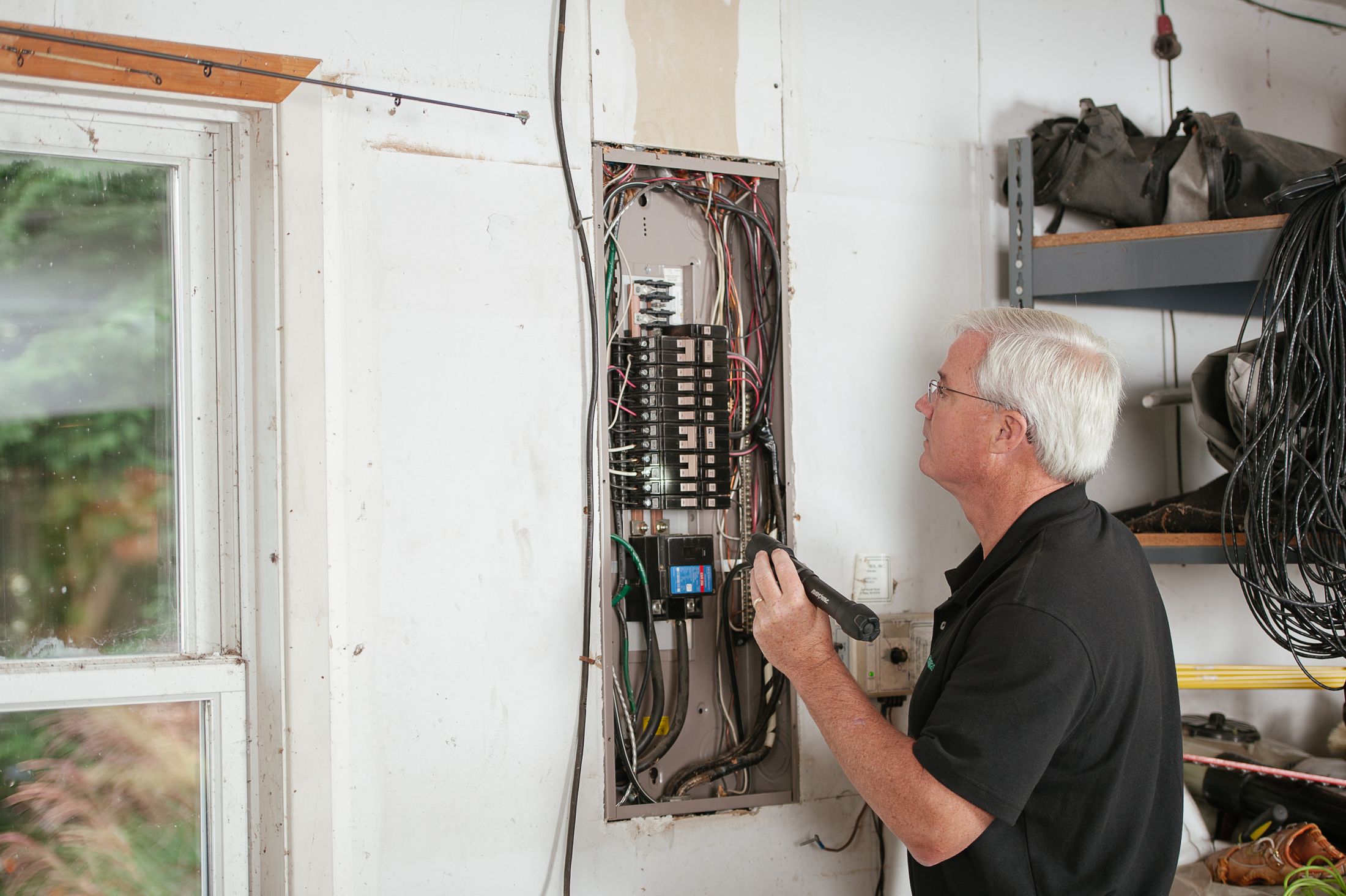 Electrician inspecting a residential fuse box