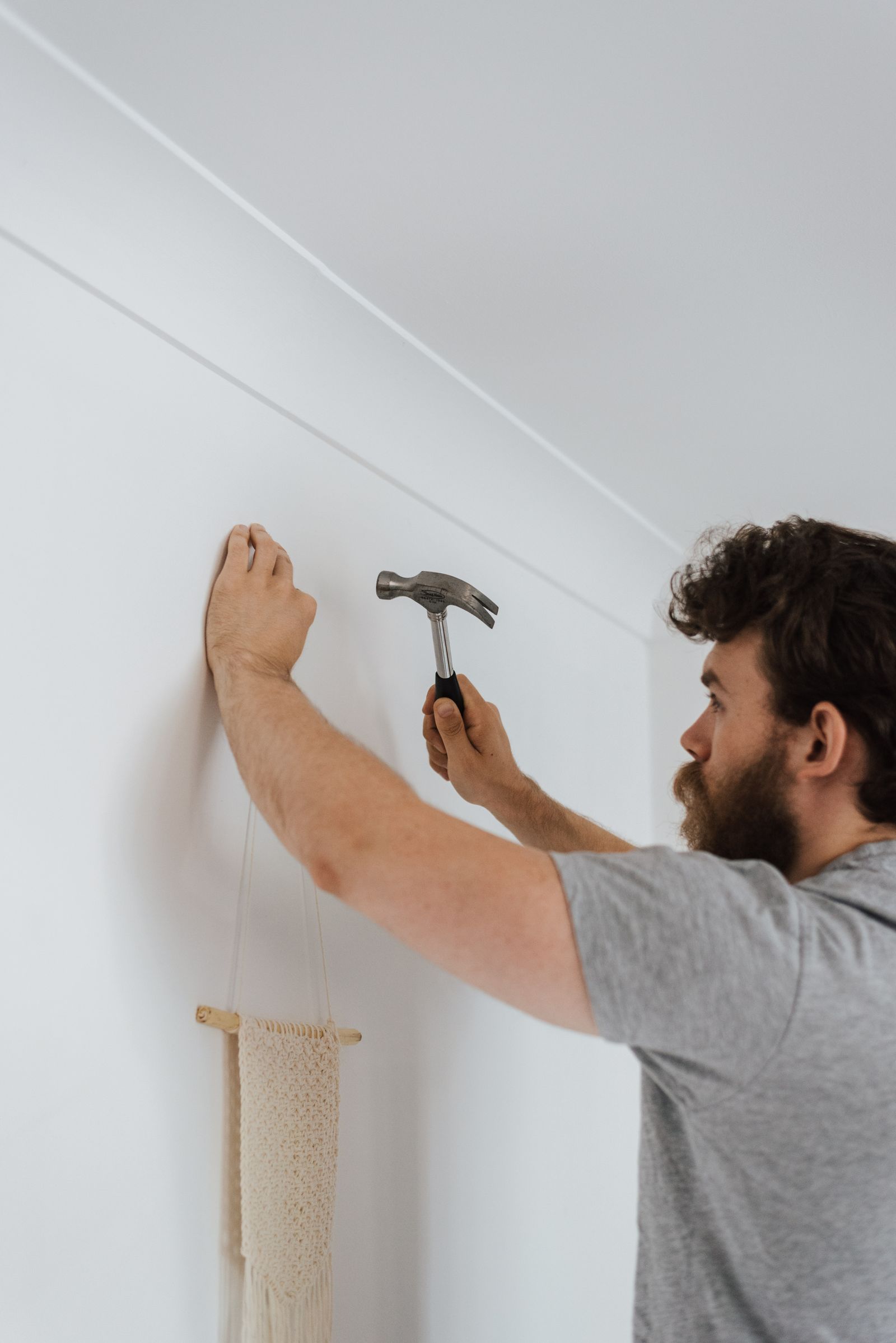 Handyman hanging a picture frame in a home