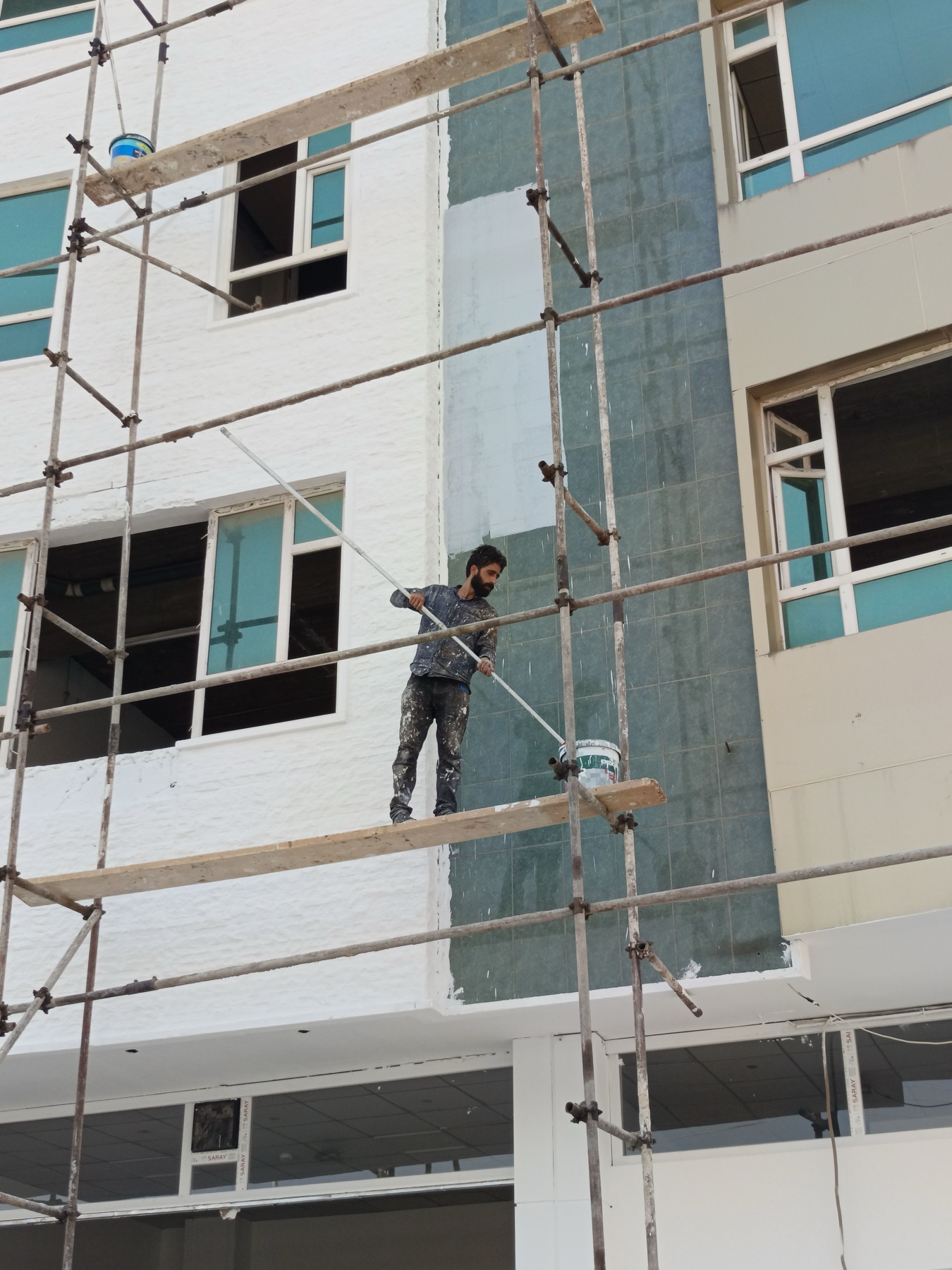 Painter working on a residential exterior from scaffolding