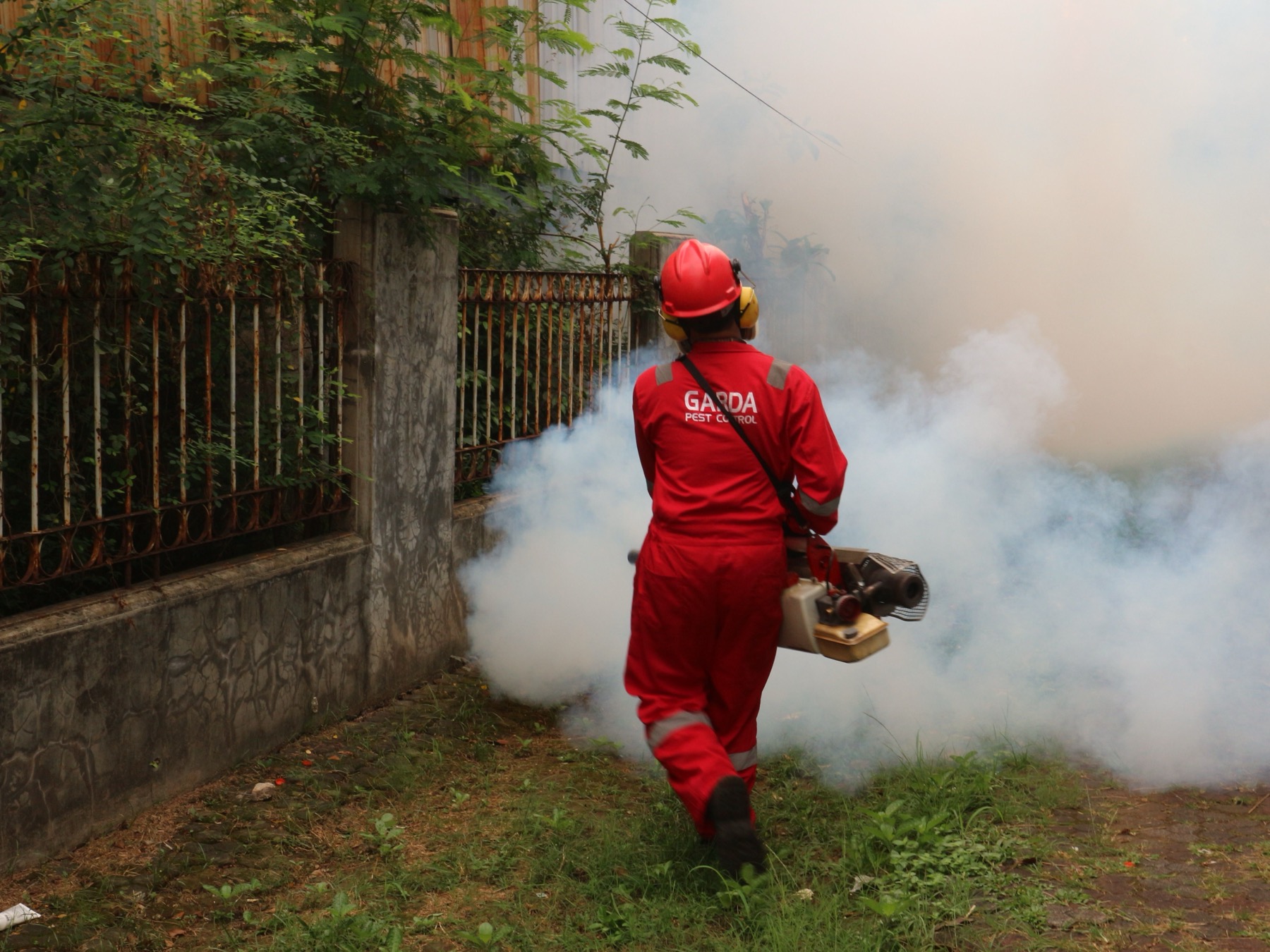 Pest-control technician treating a residential yard